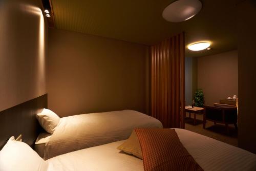 a hotel room with two beds and a desk at Meitoya So in Zao Onsen
