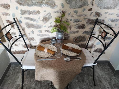 uma mesa de madeira com duas cadeiras e uma mesa com em Le Mas de la Charrette em Vinezac