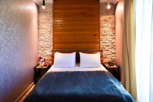 a bedroom with a blue bed with two pillows at Hotel Gold Tower in Mestia