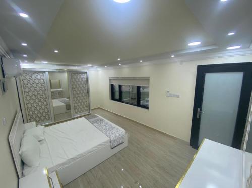 um quarto com uma cama e uma porta com um espelho em Dar Alhamra INN نزل دار الحمراء em Al Hamra