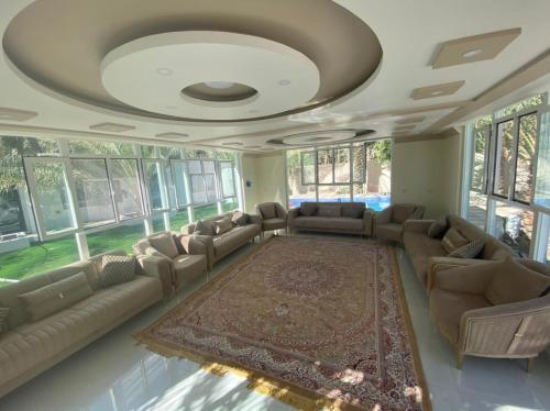 uma grande sala de estar com sofás e um tapete em Dar Alhamra INN نزل دار الحمراء em Al Hamra