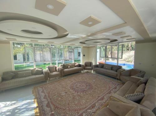 a large living room with couches and a rug at Dar Al Hamra Rest إستراحة دار الحمراء in Al Ḩamrāʼ