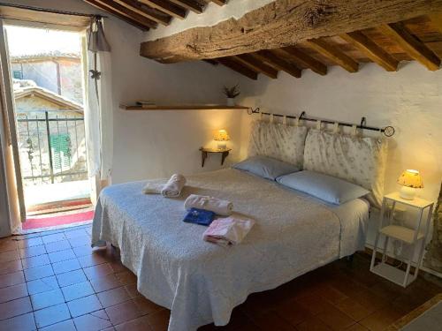 a bedroom with a bed with towels on it at Dimora Toscana in Seggiano