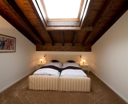 a bedroom with a large bed with a skylight at Seminar- & Erlebnishotel RömerTurm in Filzbach