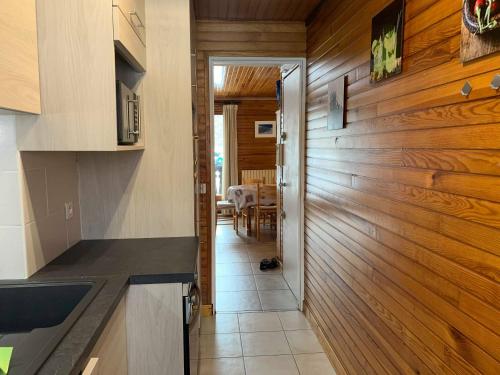 une cuisine avec des murs lambrissés et un couloir dans l'établissement mlb11, aux Carroz d'Arâches