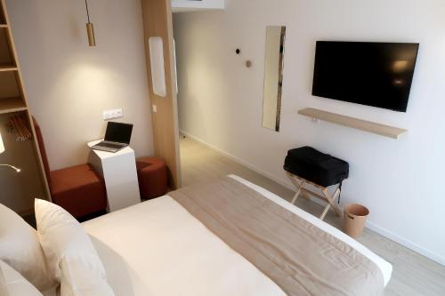 una camera d'albergo con un letto e una televisione di COURRIER SUD a Quint-Fonsegrives