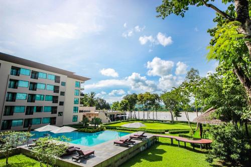 uma vista para um hotel com uma piscina e espreguiçadeiras em River Tree Resort em Chiang Khan