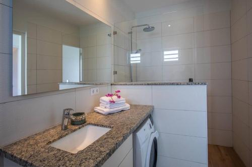 a bathroom with a sink and a mirror at Penthouse Apartment next to Blue Bay Golf & Beach! in Willemstad