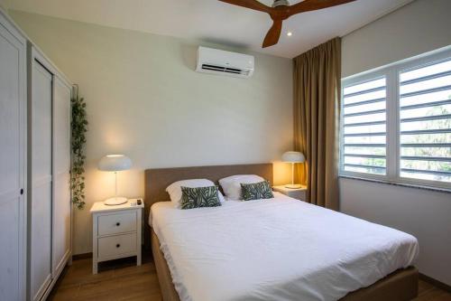 a bedroom with a large white bed with two pillows at Penthouse Apartment next to Blue Bay Golf & Beach! in Willemstad