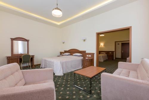 a hotel room with a bed and two chairs at Armenia Hotel in Jermuk