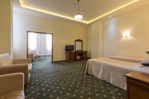 a hotel room with two beds and a television at Armenia Hotel in Jermuk