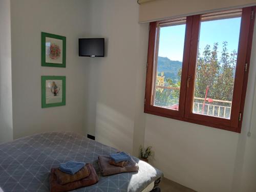 1 dormitorio con 1 cama, ventana y TV en appartamento Bel Salino, en Macerata