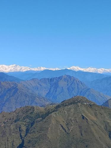an aerial view of a mountain range with snow covered mountains at Trimurti Pine Valley Resort in Shimla