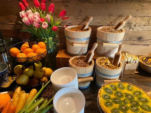 une table recouverte de paniers de nourriture et de fruits et légumes dans l'établissement Hotel Almhof, à San Candido