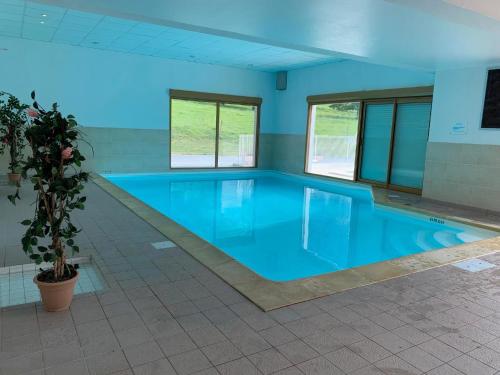 une grande piscine avec une piscine bleue dans l'établissement LE NID DU BIRDIE, Giez, Proche du lac d’Annecy, à Giez