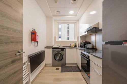 a kitchen with a washer and a washing machine at High floor 1BR vacation home with terrace in Dubai
