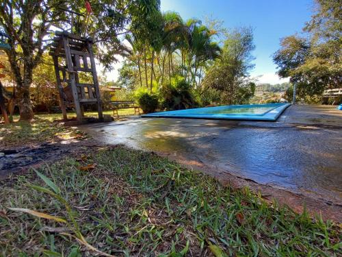 uma piscina vazia ao lado de uma estrada em Casa de campo serrana, alegre e com piscina em Lindoia