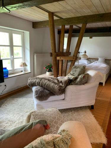 uma sala de estar com uma cama e um sofá em Kruemelkate em Witzwort
