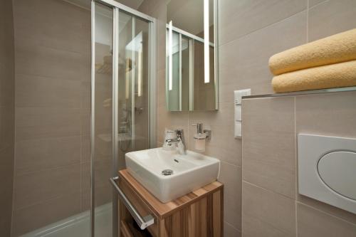 a bathroom with a sink and a glass shower at Happy Lake by Thomas Strugger in Krumpendorf am Wörthersee