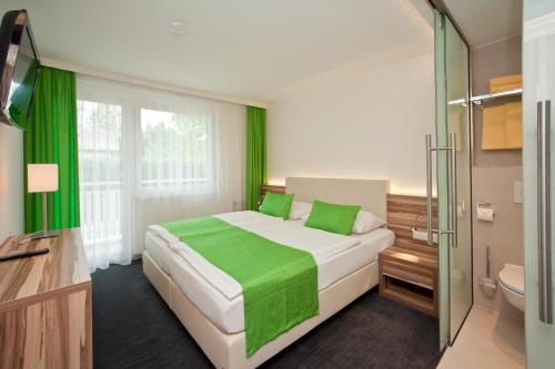 1 dormitorio con 1 cama grande con detalles verdes en Happy Lake by Thomas Strugger, en Krumpendorf am Wörthersee