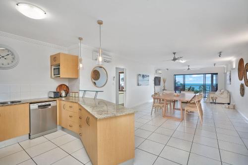 a kitchen and living room with a table and a dining room at Stunning 2-3 Bed Penthouse Glorious Ocean Views in Trinity Beach