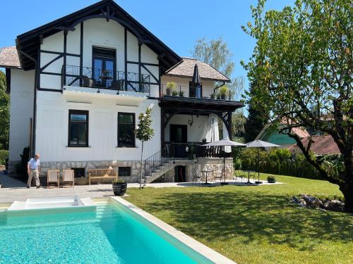 a man standing in front of a house with a swimming pool at Villa Pomona in Bled