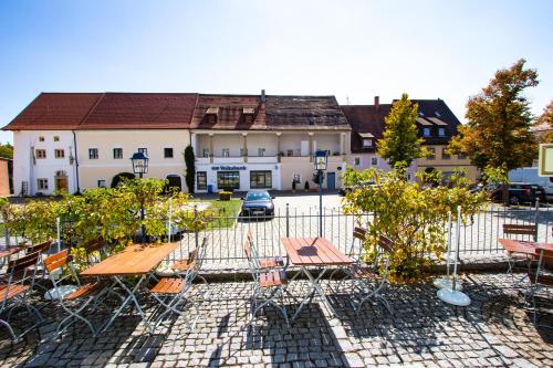 a group of tables and chairs in front of a building at Schwarzacher Hof in Niederbayern in Schwarzach