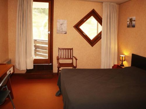 a bedroom with a bed and a window and a chair at Appartement Les Orres, 2 pièces, 6 personnes - FR-1-322-171 in Les Orres