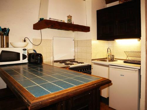 une cuisine avec un comptoir avec un micro-ondes dans l'établissement Studio familial 4 pers, skis aux pieds, proche centre - FR-1-322-229, aux Orres