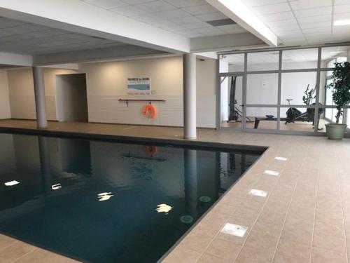 uma piscina num edifício com um cesto de basquetebol em Studio La Mongie, 1 pièce, 3 personnes - FR-1-404-261 em Bagnères-de-Bigorre