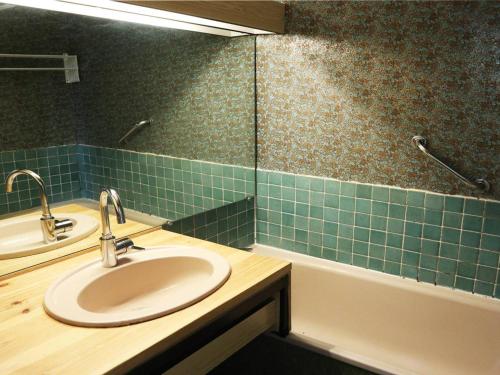 La salle de bains est pourvue d'un lavabo et de carrelage vert. dans l'établissement Appartement 6 personnes aux Orres, accès direct pistes, vue patinoire - FR-1-322-361, aux Orres