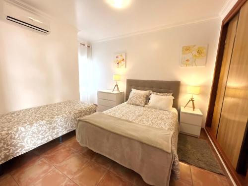 阿爾布費拉的住宿－Apartamento Roja Sol 5，一间卧室配有两张床和两盏灯。