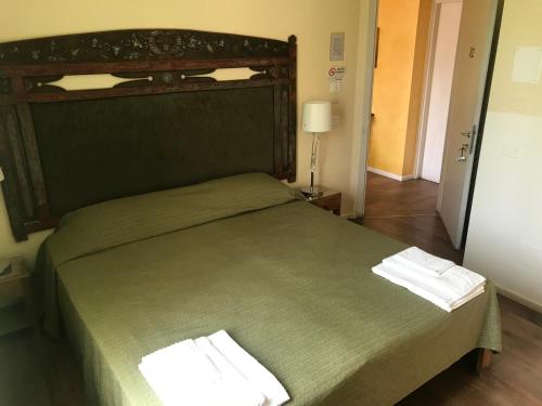 una camera da letto con un letto verde con due asciugamani di Casa Munay a Bologna