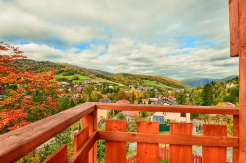 a view from the balcony of a house with a wooden railing at Apartamenty Soszów in Wisła