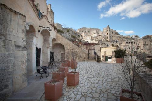 un patio con un montón de macetas en una ciudad en Fra I Sassi Residence en Matera