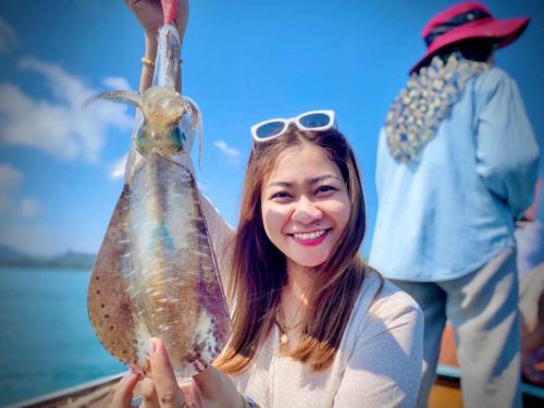 a woman holding a fish in a bottle at เกาะลิบงซันไรส์ โฮมสเตย์ Koh libong sunrise Homestay in Ko Libong