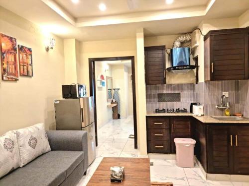 sala de estar con sofá y cocina en Comfortable & Lovely 1 Bed Apt In Bahria Town en Rāwalpindi