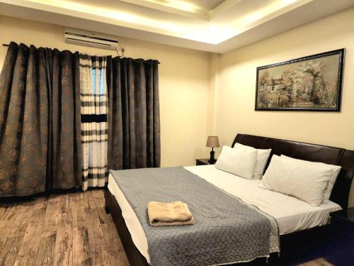 a bedroom with a bed with a towel on it at Bright & Beautiful 1 Bed Apt In Bahria Town in Rawalpindi