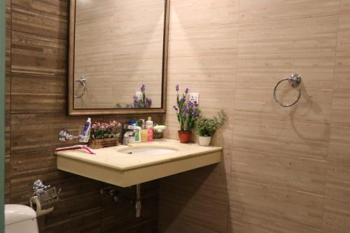 een badkamer met een wastafel en een spiegel bij Bright & Beautiful 1 Bed Apt In Bahria Town in Rawalpindi