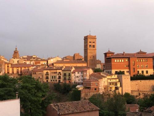 a group of buildings in a city with a clock tower at MIRADOR MUDEJAR in Teruel
