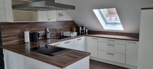 a kitchen with white cabinets and a wooden counter top at Ferienwohnung Monika in Hammelburg
