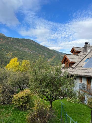a house with a mountain in the background at Bel appartement 8 personnes à Saint Chaffrey in Saint-Chaffrey