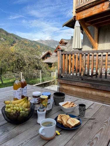 a picnic table with food and drinks on a deck at Bel appartement 8 personnes à Saint Chaffrey in Saint-Chaffrey
