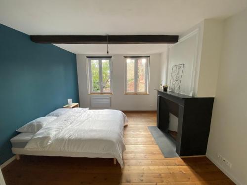 een slaapkamer met een groot bed en een open haard bij Atypique maison rénovée 3 grandes chambres - idéal famille et travailleurs in Saint-Omer