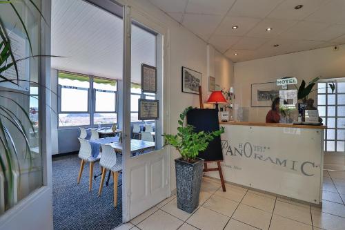 a restaurant with a table and chairs and a counter at Le Panoramic Boutique Hôtel in Nice