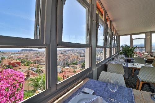a dining room with a view of the city at Le Panoramic Boutique Hôtel in Nice
