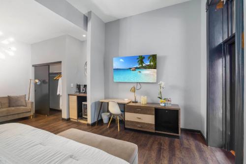 a bedroom with a bed and a desk with a computer at Good Hotels Downtown Denver in Denver