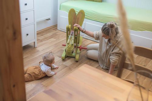 una mujer jugando con un bebé en un dormitorio en APARTMÁNY MAXOV, en Lučany nad Nisou