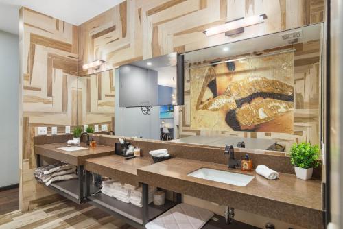 a bathroom with two sinks and a large mirror at Good Hotels Downtown Denver in Denver