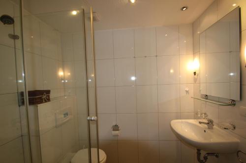 a bathroom with a shower and a sink and a toilet at Villa Ambienta WE 7 in Binz